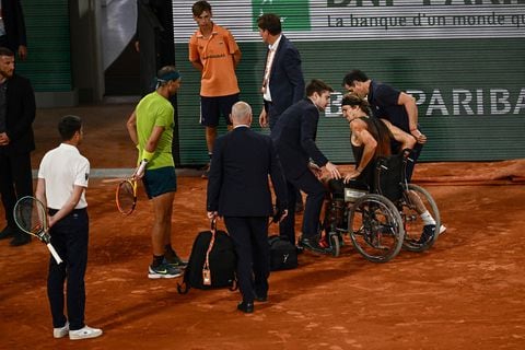 Germany's Alexander Zverev (2R) is helped to leave the court in a wheelchair after being injured during his men's semi-final singles match against Spain's Rafael Nadal (2L) on day thirteen of the Roland-Garros Open tennis tournament at the Court Philippe-Chatrier in Paris on June 3, 2022. (Photo by Anne-Christine POUJOULAT / AFP)
