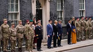Britain's Prime Minister Rishi Sunak and his wife Akshata Murty are joined outside 10 Downing Street by Ukrainian Ambassador to the UK, Vadym Prystaiko and his wife Inna, members of the Ukrainian Armed Forces and representatives from each Interflex nation, during a minute's silence to mark the one-year anniversary of the full-scale Russian invasion of Ukraine, in London, Friday, Feb. 24, 2023. (AP Photo/Alberto Pezzali)