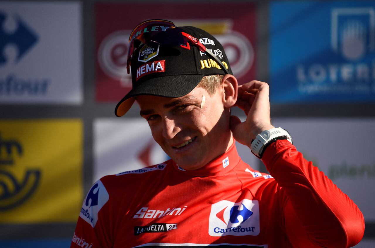 Team Jumbo-Visma's US rider Sepp Kuss wearing the overall leader's red jersey gestures on the podium after the stage 18 of the 2023 La Vuelta cycling tour of Spain, a 178,9 km race between Pola de Allande and Puerto de La Cruz de Linares on September 14, 2023. (Photo by MIGUEL RIOPA / AFP)