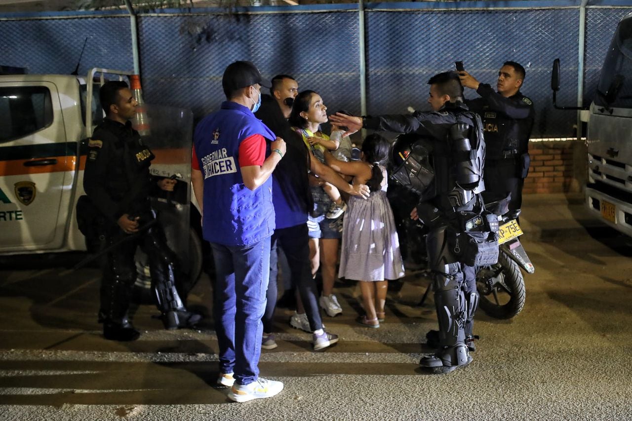 Miércoles 8 de junio de 2022. Estadio Alfonso López. Una mujer y sus hijos entre agentes del Esmad.
