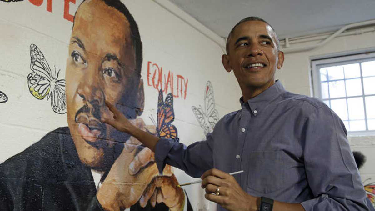 Obama ayuda a pintar el mural 'Pared de esperanza', creado por el artista Omatayo Akinbolajo, trabajando junto a una imagen de Martin Luther King Jr. Crédito: Yuri Gripas / AFP. 