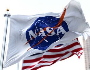 La bandera de la NASA ondeando junto con la bandera estadounidense en el fondo. AP.