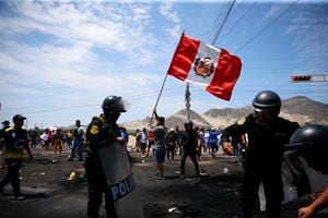 Simpatizantes del destituido presidente peruano Pedro Castillo protestan en la autopista Panamericana Norte mientras agentes de policía llegan para despejar la vía de escombros, en Chao, Perú, el jueves 15 de diciembre de 2022.