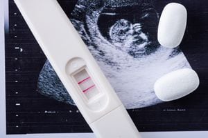 Cerca de píldoras y prueba de embarazo en imagen de ultrasonido