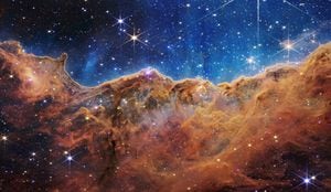 Los "Acantilados Cósmicos" de la Nebulosa Carina se ven en una imagen dividida horizontalmente por una línea ondulada entre un paisaje de nubes que forma una nebulosa a lo largo de la parte inferior y una parte superior comparativamente clara, con datos del Telescopio Espacial James Webb de la NASA, un aparato revolucionario diseñado para mirar a través del cosmos hasta el amanecer del universo y lanzado el 12 de julio de 2022. Moteado en ambas partes hay un campo de estrellas, que muestra innumerables estrellas de muchos tamaños. NASA, ESA, CSA, STScI, Foto Webb ERO Production Team/a través de REUTERS