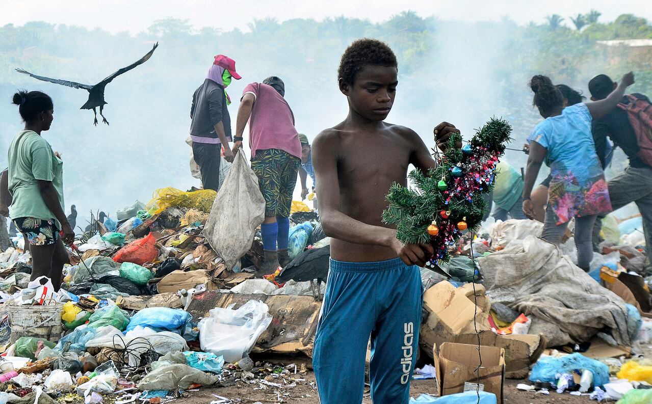 Gabriel Silva sostiene una decoración navideña que encontró mientras buscaba basura en un vertedero de Brasil.