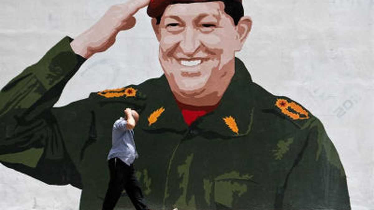 n hombre camina frente a un mural pintado con la imagen del presidente de Venezuela, Hugo Chávez, el sábado, en las calles de Caracas (Venezuela).