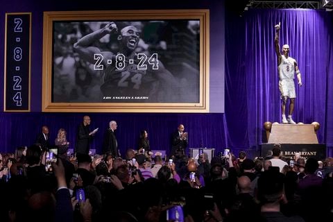 Los asistentes ven una estatua del ex guardia de Los Ángeles Lakers, Kobe Bryant, después de su inauguración fuera del estadio del equipo de baloncesto de la NBA, el jueves 8 de febrero de 2024, en Los Ángeles. (Foto AP/Eric Thayer)