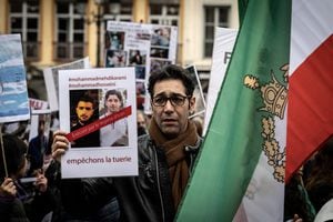 Un manifestante sostiene retratos de los iraníes Mohammad Mehdi Karami (L) y Mohammad Hosseini (2nd-L), manifestantes que fueron ejecutados recientemente en Irán, durante una manifestación en Lyon el 8 de enero de 2023 contra el régimen iraní