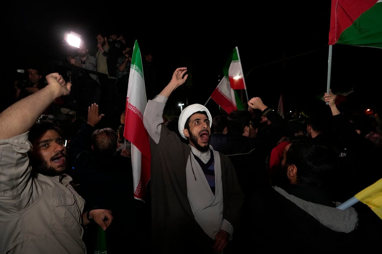 Iranian demonstrators chant slogans during their anti-Israeli gathering in front of the British Embassy in Tehran, Iran, early Sunday, April 14, 2024. Iran launched its first direct military attack against Israel on Saturday. (AP Photo/Vahid Salemi)