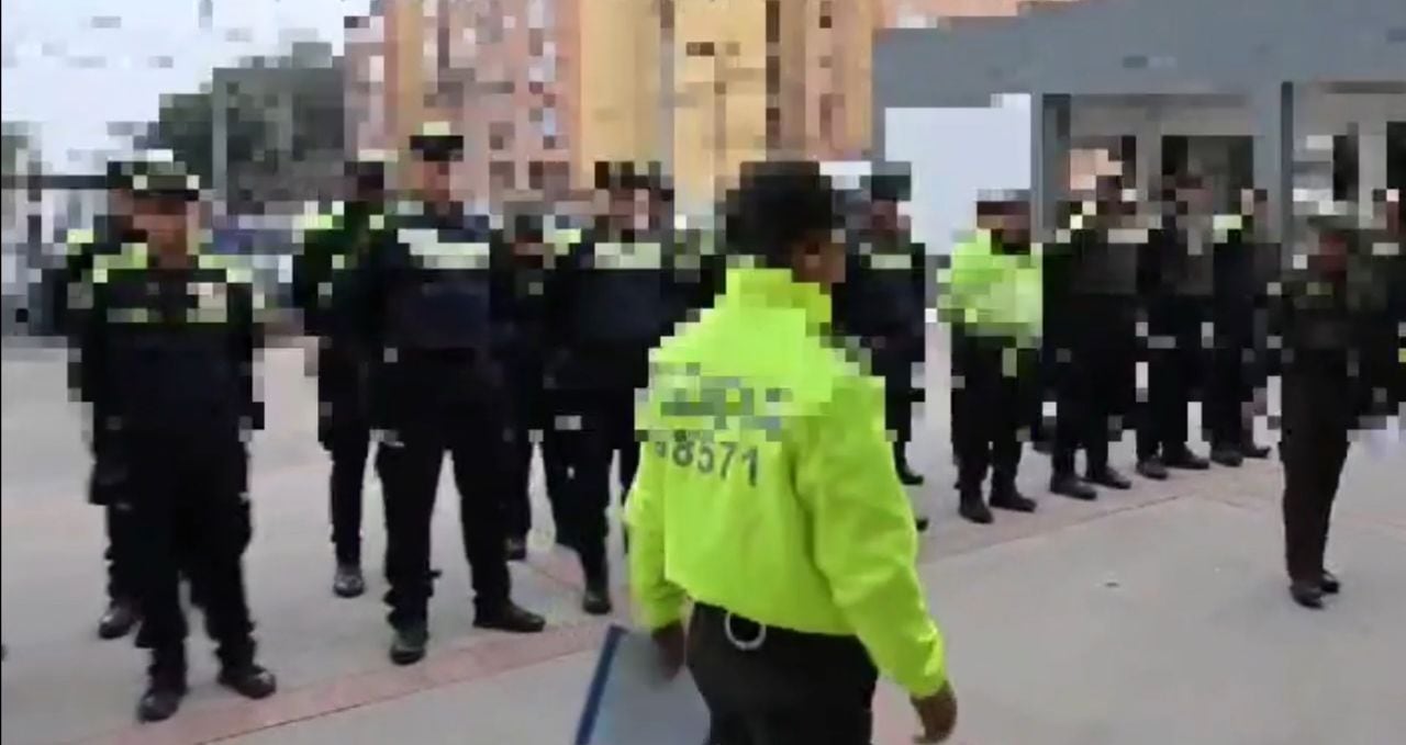 Momento en el que el agente de chaqueta verde llega a capturar a un patrullero que se encontraba formando en el CAI de Fontibón.