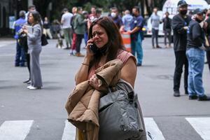 A woman speaks on her phone after an earthquake in Mexico City on September 19, 2022. - A 6.8-magnitude earthquake struck western Mexico on Monday, shaking buildings in Mexico City on the anniversary of two major tremors in 1985 and 2017, seismologists said. (Photo by RODRIGO ARANGUA / AFP)