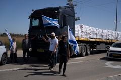Sosteniendo banderas israelíes, personas se paran frente a camiones que transportan ayuda humanitaria mientras intentan detenerlos para ingresar a la Franja de Gaza en un área cerca del cruce fronterizo de Kerem Shalom entre Israel y Gaza, en el sur de Israel, en Kerem Shalom, el jueves 9 de mayo. , 2024.