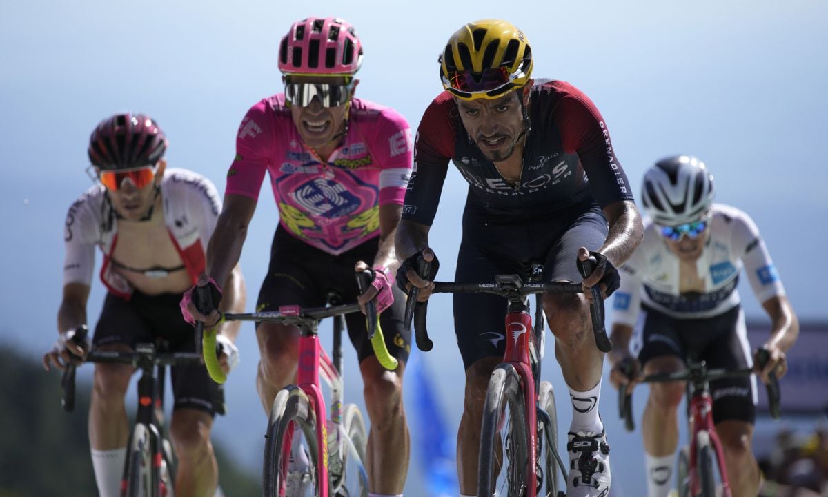Daniel Martinez of Ecuador, center right, crosses the finish line of the seventh stage of the Tour de France cycling race over 176.5 kilometers (109.7 miles) with start Tomblaine and finish in La Super Planche des Belles Filles, France, Friday, July 8, 2022. (AP/Daniel Cole)