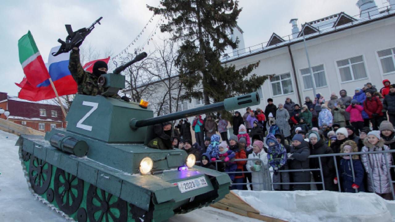 Archivo de los participantes descienden por una pendiente en un trineo, que representa un tanque con el símbolo "Z" en apoyo de las fuerzas armadas rusas.