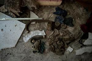 Máscaras antigás de la era soviética yacen en el piso del corredor de la Escuela No. 2 que se usó como base militar rusa y lugar de tortura en la ciudad recientemente recuperada de Izium, Ucrania, el miércoles 21 de septiembre de 2022.  (AP Photo/Evgeniy Maloletka)