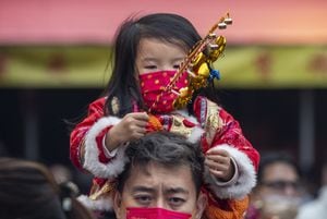 Un padre lleva a su hijo sobre sus hombros en el templo Sha Tin Che Kung el tercer día del Año Nuevo Lunar