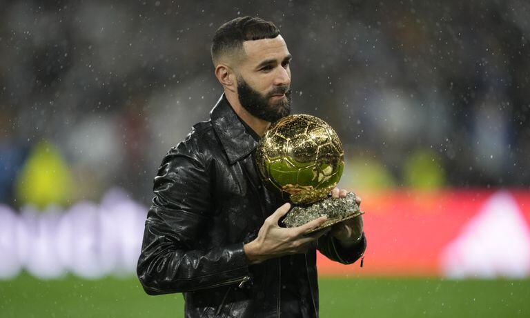 Real Madrid's Karim Benzema holds the 2022 Ballon d'Or trophy prior to the Spanish La Liga soccer match between Real Madrid and Sevilla at the Santiago Bernabeu stadium in Madrid, Saturday, Oct. 22, 2022. (AP/Manu Fernandez)