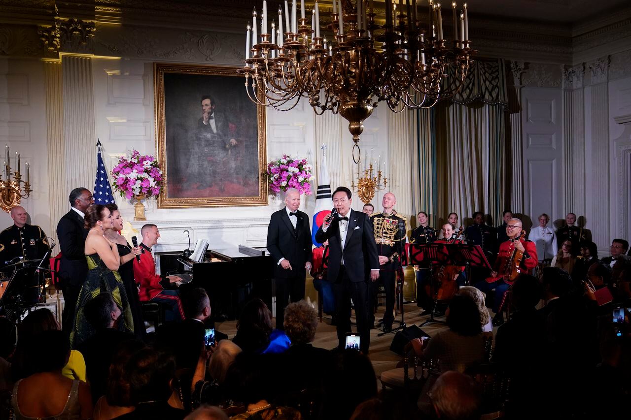 El presidente Joe Biden escucha mientras el presidente de Corea del Sur, Yoon Suk Yeol, canta la canción American Pie de Don Mclean en el Comedor de Estado de la Casa Blanca en Washington
