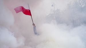 Una persona ondea una bandera polaca rodeada de humo mientras los agricultores protestan frente a la oficina del primer ministro polaco Donald Tusk contra el Acuerdo Verde de la Unión Europea y las importaciones de productos agrícolas ucranianos, en Varsovia, Polonia, el 6 de marzo de 2024.