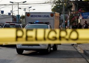 Una cinta policial dice "Peligro" en la escena del crimen donde agentes de policía fueron asesinados en respuesta a los traslados de prisioneros desde prisiones superpobladas, lo que llevó al presidente Guillermo Lasso a declarar el estado de emergencia en dos provincias, en Guayaquil, Ecuador