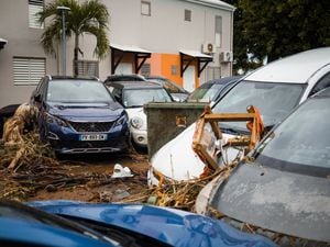 This photograph taken on September 18, 2022, shows debris and cars swept away and overlapping each other after the passage of Hurricane Fiona in Goyave, on the French island of Guadeloupe. (Photo by Carla Bernhardt / AFP)