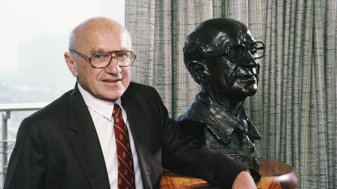 El economista ganador del Premio Nobel Milton Friedman posa con una escultura de sí mismo durante una sesión de retratos fotográficos en 1986 en San Francisco, California.