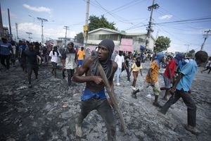 Un manifestante lleva un trozo de madera que simula un arma durante una protesta exigiendo la renuncia del primer ministro Ariel Henry, en el área de Petion-Ville de Puerto Príncipe, Haití, el lunes 3 de octubre de 2022. 