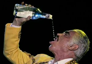 ARCHIVO- El cantante mexicano Vicente Fernández toma aguardiente durante un concierto en Cali, Colombia, el 21 de febrero de 2009. Fernández, galardonado con tres Grammy y nueve Latin Grammy murió el 12 de diciembre de 2021. (Foto AP/Christian Escobar Mora, archivo)