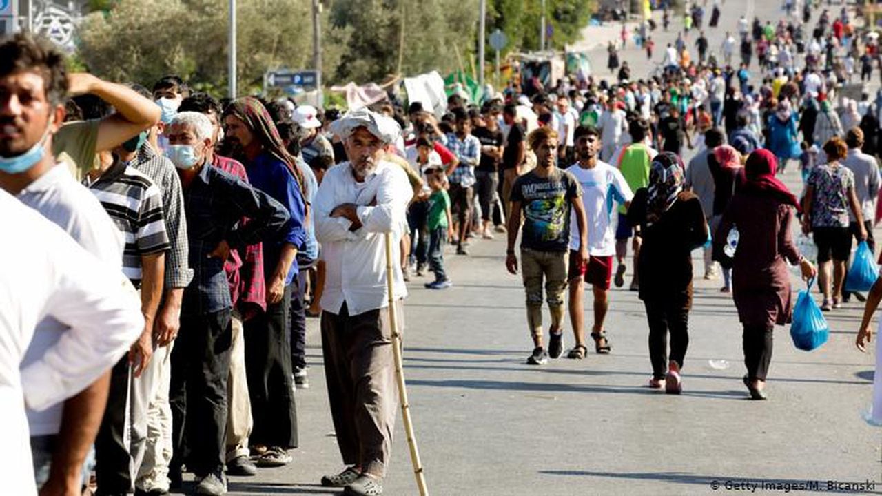 Migrantes del antiguo campo de Moria forman largas filas para recibir alimentos y agua en la isla de Lesbos.