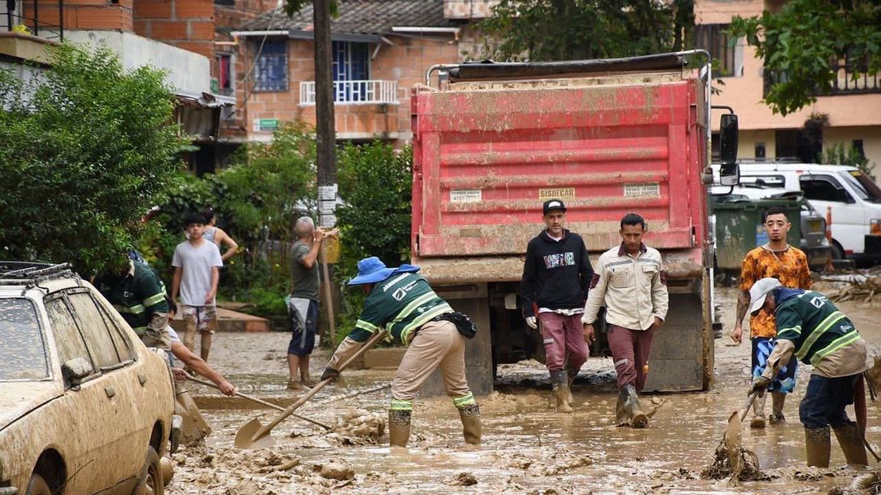 Personal de la Defensa Civil y la Cruz Roja Colombiana que se encuentran en el sitio colaboran con las labores de remoción del lodo y el agua que anegó las viviendas y las calles.