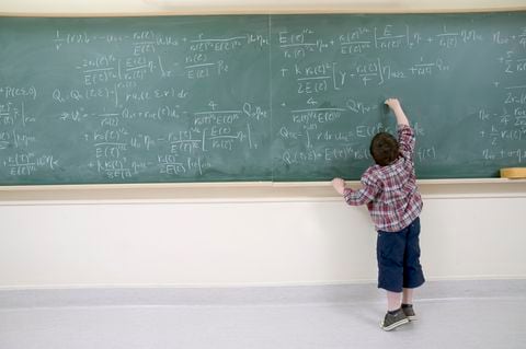Boy Working Out Complex Equation on Blackboard