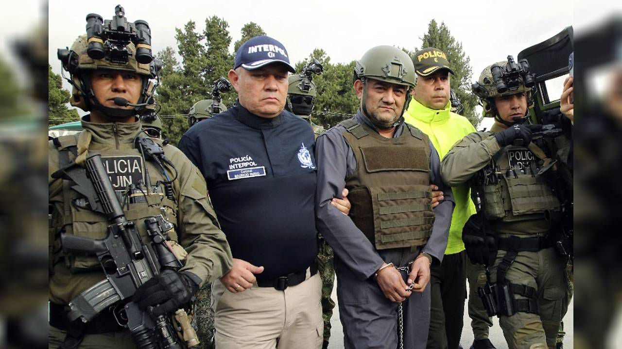 En esta foto difundida por la Oficina de Prensa de la Presidencia de Colombia el 4 de mayo de 2022, la Policía escolta a "Otoniel", antes de su extradición.