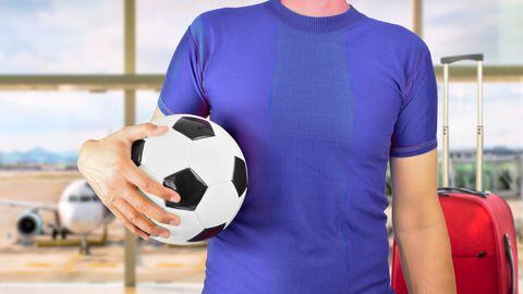 Foto de referencia de un joven con un balón de fútbol en una aeropuerto