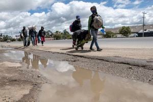 June 19, 2020. Colombia: A group of Venezuelan is walking on the highway a few kilometers after Bogota. They are coming from Lima (Peru), from where they left a month ago. They are going to Valencia in Venezuela. They start walking in the morning at 6am and stop around 5pm. In the last few days, they are only 10 km a day because one of the women is 4 months pregnant. They wash themselves in the rivers they come across or in the petrol stations. Credit: Nadège Mazars for NRC