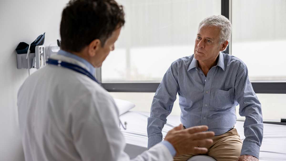 Latin American doctor talking to a patient in a consultaton at his office practice - healthcare and medicine concepts