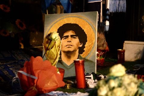 A picture of late Argentinian soccer player Diego Armando Maradona is displayed among flowers in the Spanish district of Naples on November 25, 2021. - Naples is paying tribute to Diego Maradona on the first anniversary of his death with three statues, two to be set up in the recently renamed Diego Armando Maradona football stadium and one already sitting in the city's National Archaeological Museum. (Photo by Filippo MONTEFORTE / AFP)