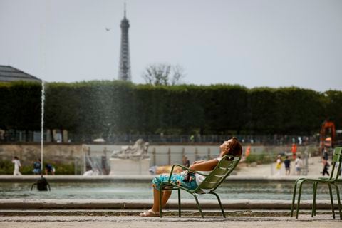 Una mujer disfruta del sol en los jardines de las Tullerías, el 10 de julio de 2023 en París. Los científicos dicen que las temperaturas aplastantes que cubrieron Europa el verano pasado pueden haber provocado más de 61,000 muertes