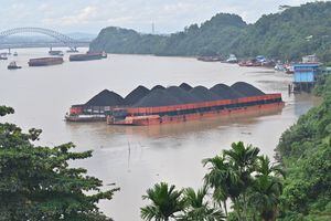 In this picture taken on August 16, 2022 piles of coal are seen on barges in Samarinda, East Kalimantan. (Photo by ADEK BERRY / AFP)