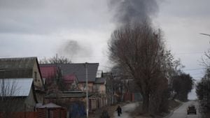 Un residente local camina en una calle mientras el humo se eleva cerca de la ciudad de Hostomel y el aeropuerto Antonov, en el noroeste de Kiev el 24 de febrero de 2022.