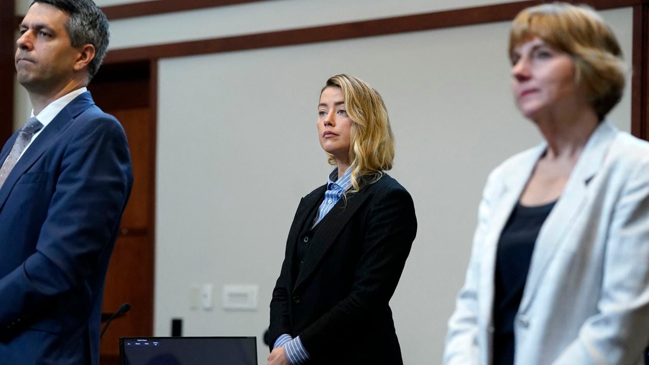 La actriz estadounidense Amber Heard (C) de pie en la sala del tribunal con su equipo legal en el Tribunal de Circuito del Condado de Fairfax, durante un caso de difamación en su contra por parte de su exesposo, el actor estadounidense Johnny Depp.