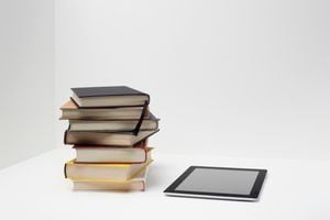 Pila de libros con tableta digital, lectura