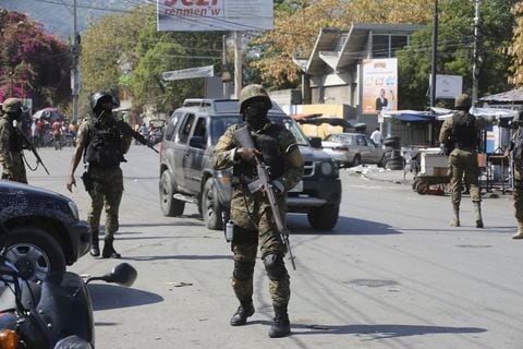 Elementos de la Unidad de Seguridad General del Palacio Nacional de Haití establece un perímetro para retomar el control de una de las tres delegaciones de policía que fueron tomadas por pandillas, en el centro de Puerto Príncipe, Haití, el sábado 9 de marzo de 2024. (AP Foto/Odelyn Joseph)