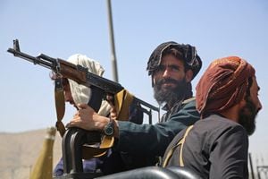 Combatientes talibanes montan guardia en un vehículo a lo largo de la carretera en Kabul el 16 de agosto de 2021, después de un final asombrosamente rápido de la guerra de 20 años de Afganistán, mientras miles de personas asaltaban el aeropuerto de la ciudad tratando de huir del temido tipo de gobierno islamista de línea dura del grupo. (Foto de - / AFP)