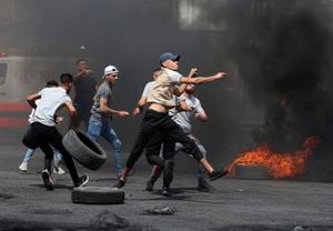 Palestinian protesters hurl rocks amid confrontations with Israeli security forces at the Hawara checkpoint south of Nablus city, in the occupied West Bank, on May 21, 2021, following demonstrations in support of Palestinians in Jerusalem's Sheikh Jarrah and the Gaza Strip. (Photo by JAAFAR ASHTIYEH / AFP)