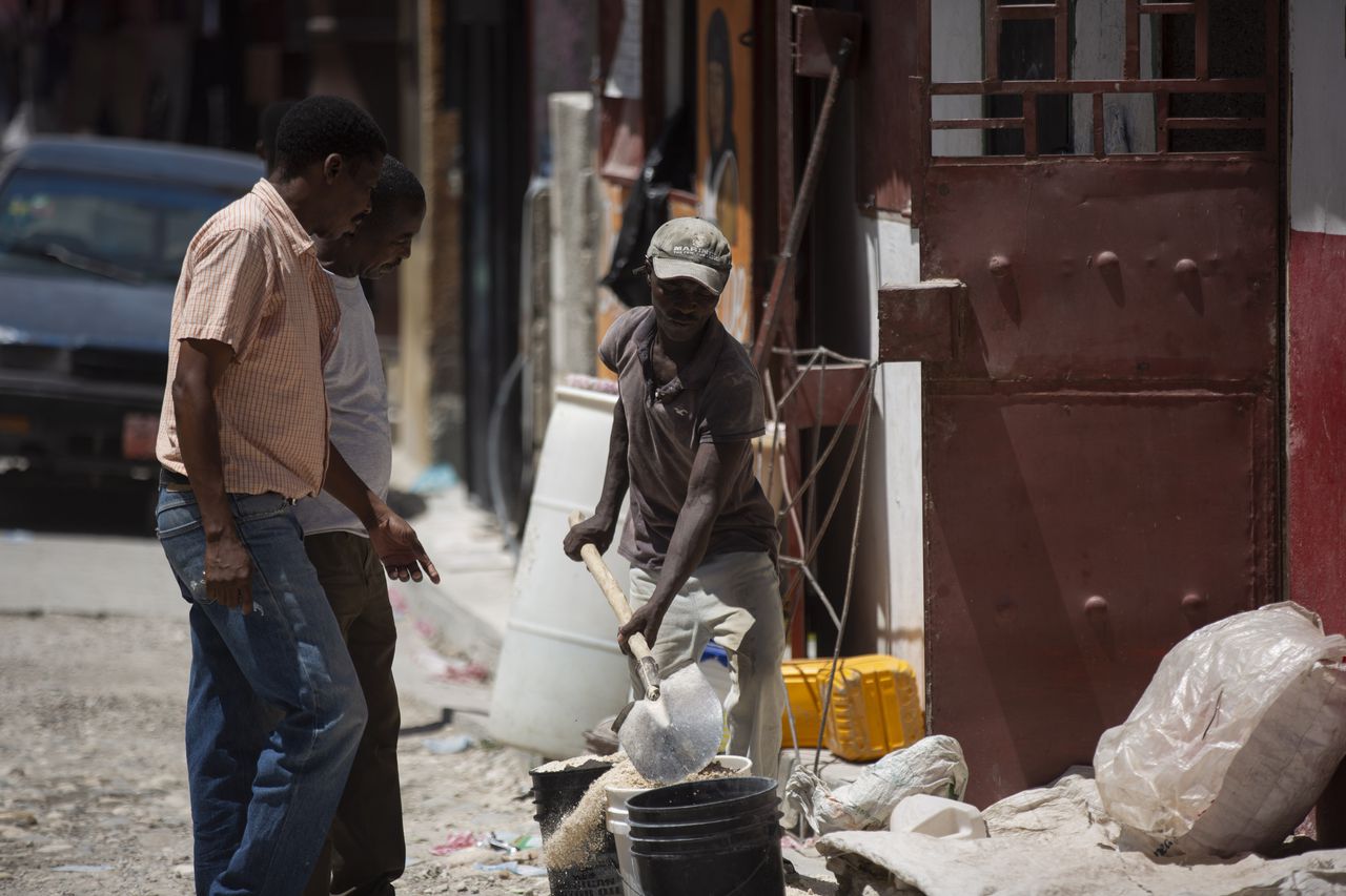 A worker shovels sands at a construction site in Port-au-Prince, Haiti, Saturday, Aug. 14, 2021.  A 7.2 magnitude earthquake struck Haiti on Saturday, with the epicenter about 125 kilometers (78 miles) west of the capital of Port-au-Prince, the U.S. Geological Survey said. (AP Photo/Joseph Odelyn)