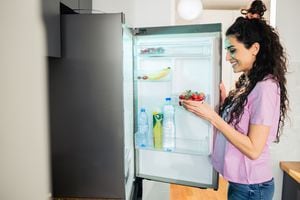 Woman searching for food in fridge at kitchen