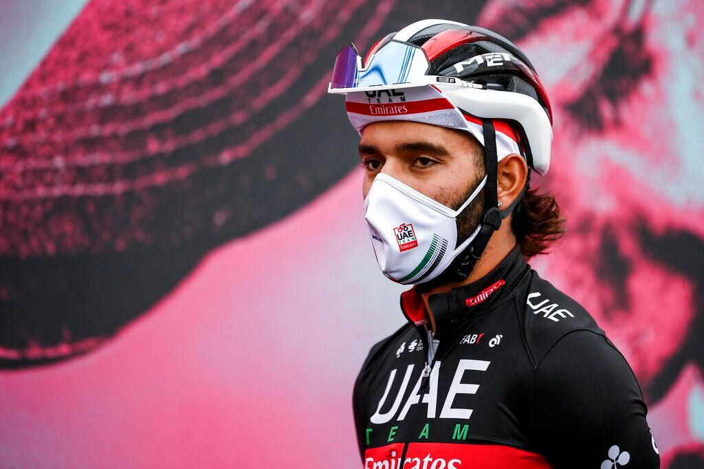 Cyclist Fernando Gaviria wears a face mask to curb the spread of COVID-19 as he attends the 13th stage of the Giro d'Italia cycling race, from Cervia to Monselice, Italy, on Friday, Oct. 16, 2020. Colombian sprinter Gaviria is the latest cyclist to test positive for the coronavirus and be withdrawn from the Giro d’Italia. Gaviria and a staff member for Team AG2R La Mondiale were the only positives out of 492 tests carried out Sunday and Monday, Oct. 19, 2020. (Marco Alpozzi/LaPresse via AP)