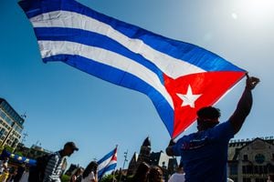 Un hombre sostiene una gran bandera cubana, durante la manifestación en apoyo a Cuba. (Photo by Romy Arroyo Fernandez/NurPhoto via Getty Images)