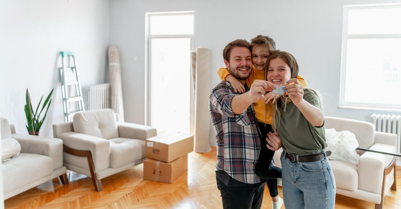 Una familia joven estadounidense emocionada muestra las llaves de su propia casa, una pareja feliz que compra la primera casa juntos, un esposo y una esposa sonrientes compran una nueva propiedad. Concepto de propiedad